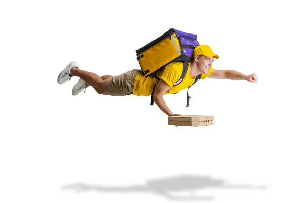 Young delivery man in yellow uniform flying to deliver order isolated on white background. Concept of convenience, speed, comfort, safety, service. — Stock Photo, Image