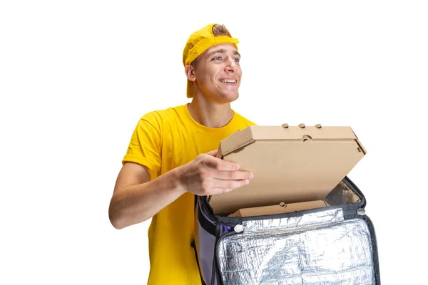 Primer plano joven repartidor en uniforme amarillo con caja de papel con pizza aislada sobre fondo blanco. Concepto de conveniencia, velocidad, comodidad, seguridad, servicio. — Foto de Stock