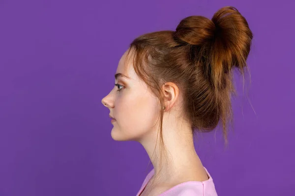 Zijaanzicht. Portret van jong mooi meisje geïsoleerd op paarse, lila kleur studio achtergrond. Concept van menselijke emoties, gezichtsuitdrukking, natuurlijke schoonheid, jeugd — Stockfoto