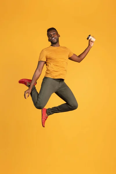 Retrato de un joven africano con ropa casual aislado sobre fondo de estudio de color amarillo. Concepto de emociones humanas, expresión facial, juventud, sentimientos, ad. —  Fotos de Stock