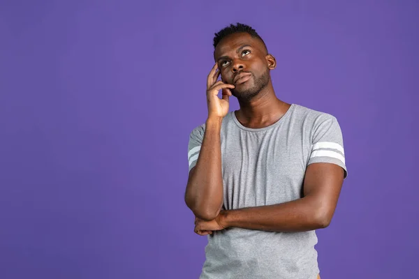 Un jeune homme afro-américain isolé sur fond studio couleur pourpre. Concept d'émotions humaines, expression faciale, jeunesse, sentiments, publicité. — Photo