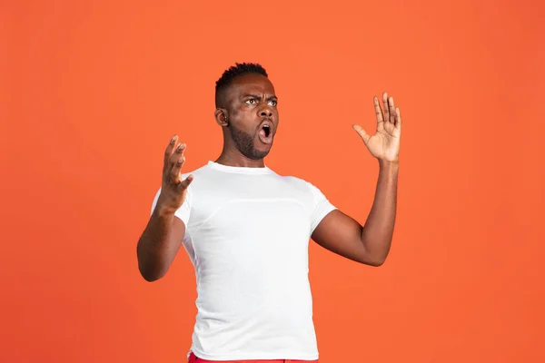 Πορτρέτο του αφρικανού νεαρού άνδρα σε casual ρούχα που απομονώνονται σε φόντο στούντιο κόκκινο χρώμα. Έννοια των ανθρώπινων συναισθημάτων, έκφραση προσώπου, νιάτα, συναισθήματα, διαφήμιση. — Φωτογραφία Αρχείου