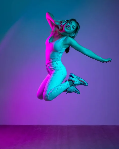 Retrato de una joven hermosa chica aislada sobre fondo de estudio azul en filtro de luz de neón. Concepto de emociones humanas, expresión facial, juventud, ventas, anuncio. — Foto de Stock