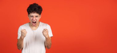 El ilanı. Asyalı adam portresi kırmızı stüdyo arka planında izole edilmiş ve reklam için kopyalanmış. İnsan duyguları, moda, güzellik, gençlik kavramı