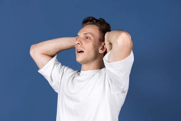 One Caucasian young man isolated on navy blue color studio background. Concept of human emotion, facial expressions, youth, feelings, ad. — Stock Photo, Image