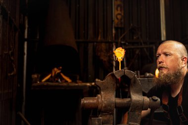 Güzel gül. Demirci, demircide kıvılcım saçan havai fişeklerle örse erimiş metali elle dövüyor. Çalışma anlayışı, geçmişe dönük meslekler, aile meslekleri