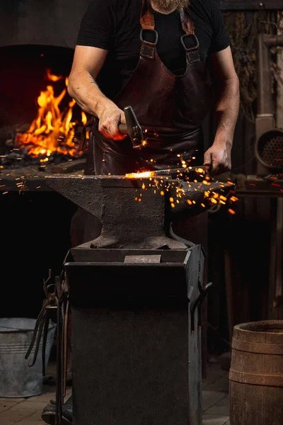 Colpo ritagliato di uomo, fabbro che lavora alla creazione di prodotti in metallo fatti a mano da fabbro di famiglia. Concetto di lavoro, professioni retrò, potere, bellezza — Foto Stock