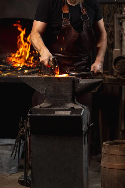 Tiro de homem cortado, ferreiro trabalhando na criação de produtos metálicos artesanais em ferreiro da família. Conceito de trabalho, profissões retro, poder, beleza — Fotografia de Stock