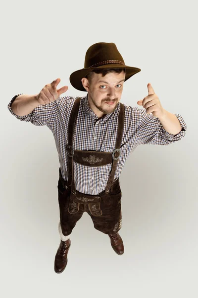 Bonito homem barbudo feliz, garçom em traje tradicional austríaco ou bávaro de pé sozinho isolado sobre fundo cinza. Emoções engraçadas — Fotografia de Stock