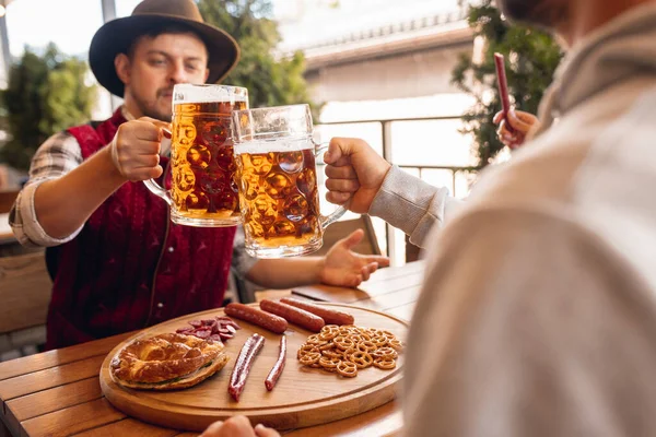 Группа друзей встречается в баре, кафе и пьет пиво на пивном фестивале. Традиции, веселье, радость, дружба, праздники. Октоберфест, октябрь, осенняя концепция — стоковое фото