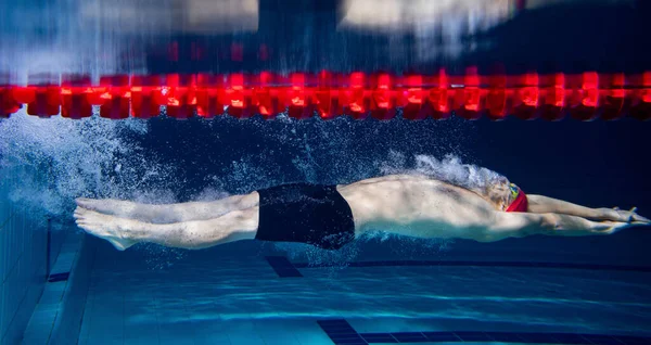 En manlig simmare tränar och tränar vid poolen, inomhus. Undervattensvy av simning rörelser detaljer. hälsosam livsstil, makt, energi, sport rörelse koncept. — Stockfoto