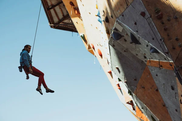 Un hombre caucásico escalador profesional practicando en el centro de entrenamiento en un día soleado, al aire libre. Concepto de estilo de vida saludable, turismo, naturaleza, movimiento. — Foto de Stock