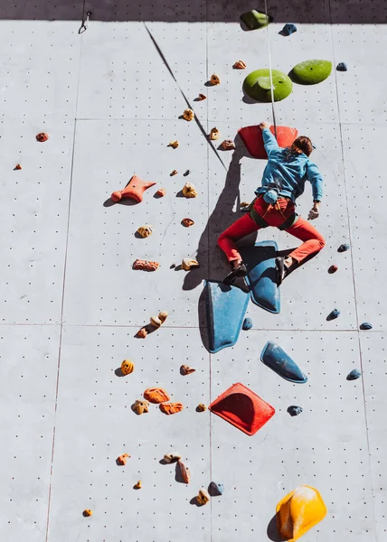 Un hombre caucásico entrenamientos profesionales escalador de roca en el centro de entrenamiento en el día soleado, al aire libre. Concepto de estilo de vida saludable, turismo, naturaleza, movimiento. — Foto de Stock