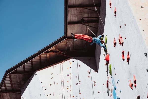 Trucchi difficili. Giovane arrampicatore professionista che pratica al centro di allenamento nella giornata di sole, all'aperto. Concetto di stile di vita sano, attività — Foto Stock