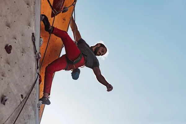 Entraînement quotidien. Jeune homme alpiniste professionnel pratiquant au centre d'entraînement par temps ensoleillé, en plein air. Concept de mode de vie sain, activité physique — Photo
