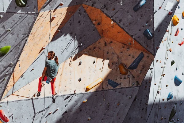 Un hombre caucásico escalador profesional practicando en el centro de entrenamiento en un día soleado, al aire libre. Concepto de estilo de vida saludable, turismo, naturaleza, movimiento. — Foto de Stock