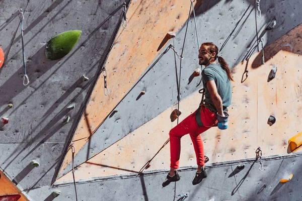 Un homme caucasien alpiniste professionnel pratiquant au centre d'entraînement dans la journée ensoleillée, en plein air. Concept de mode de vie sain, tourisme, nature, mouvement. — Photo