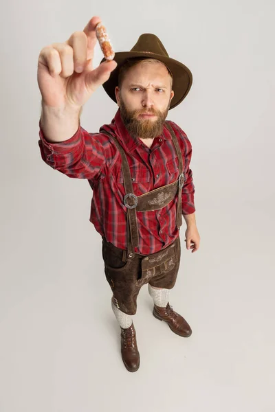 Комічний портрет бородатого чоловіка в капелюсі і традиційний баварський костюм з величезною кухнею, склянкою світлого мокрого пива і ізольованим на білому тлі. Октоберфест — стокове фото