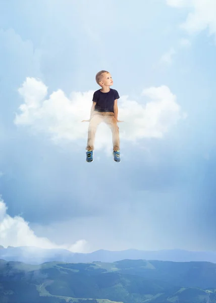Творческий коллаж с маленьким дошкольником, сидящим на белом облаке и летающим на небе, на открытом воздухе. Концепция детства, счастья, мечтаний, приключений — стоковое фото
