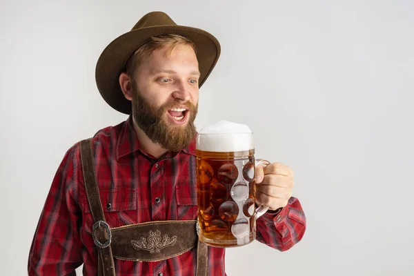 Половинний портрет бородатого чоловіка в капелюсі і традиційний баварський костюм з величезним кухлем, склянка світлого фритюрного пива, ізольованого на білому тлі. Флаєр — стокове фото