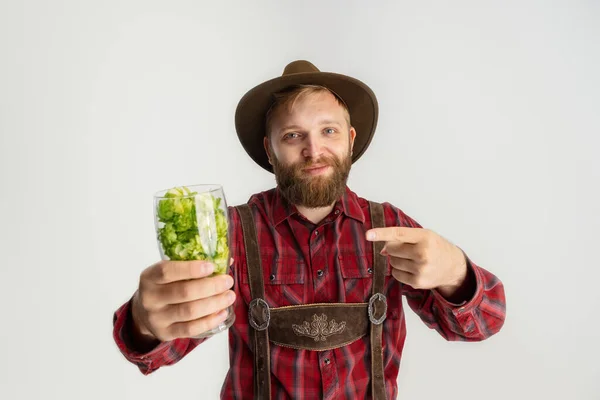 Feliz hombre sonriente vestido con traje tradicional bávaro sosteniendo vasos de cerveza llenos de salvaje caliente y cebada. Celebración, oktoberfest, concepto de festival. — Foto de Stock