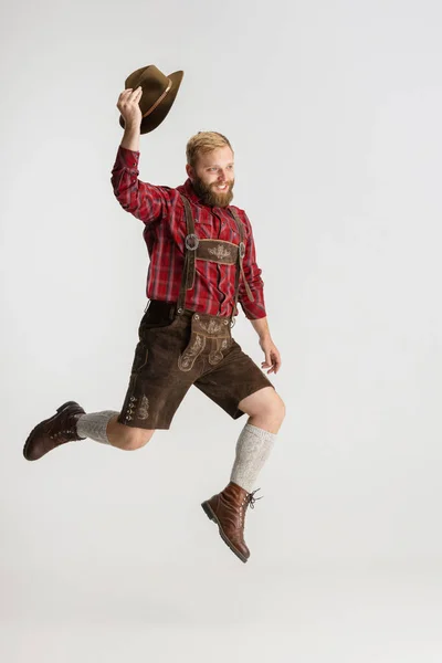 Retrato completo de homem barbudo de chapéu e traje tradicional bávaro pulando alto isolado sobre fundo branco. Folheto, conceito oktoberfest — Fotografia de Stock