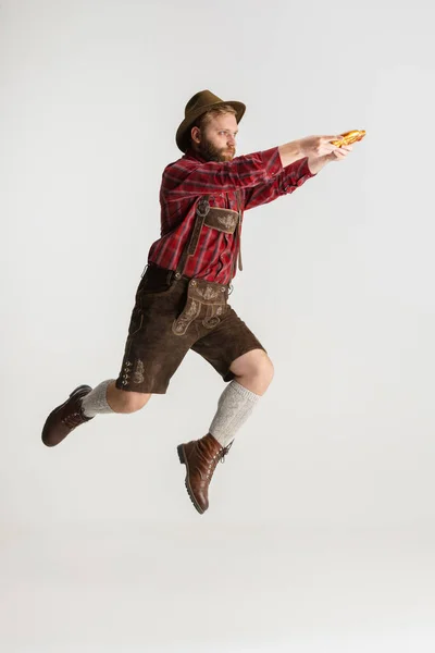 Retrato de cuerpo entero de hombre barbudo con sombrero y traje bávaro tradicional saltando alto aislado sobre fondo blanco. Volante, concepto oktoberfest — Foto de Stock