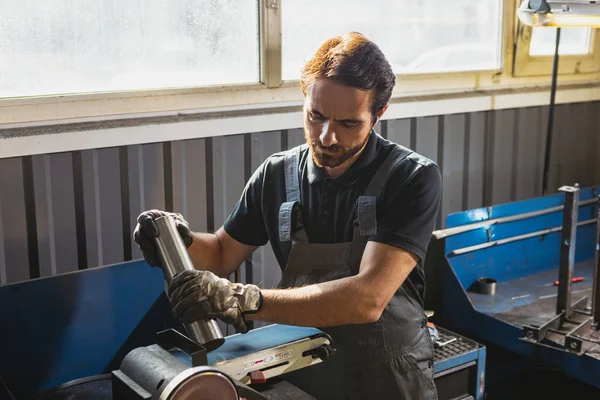 Portrait of young man, male auto mechanic in dungarees working at car service station, indoors. Concept of labor, occupation, business, caree, job — Stock Photo, Image