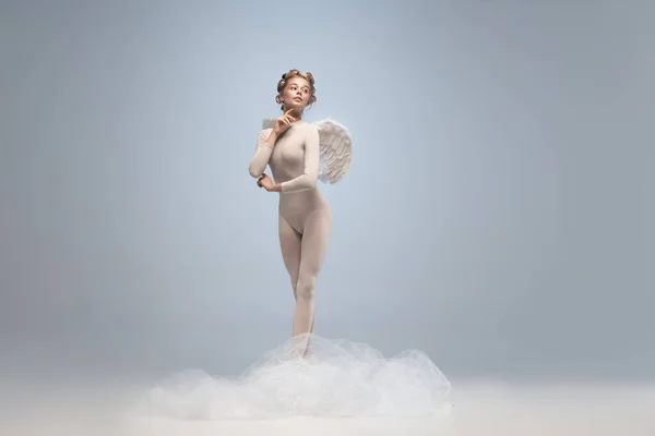 회색 스튜디오 배경에 날개가 고립된 천사의 모습을 한 아름다운 발레리나의 전신 초상화. 예술, 운동, 행동, 유연성, 영감의 개념. — 스톡 사진