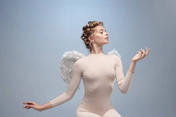 Portret czułej, pięknej młodej dziewczyny, pełna wdzięku balerina na obraz anioła ze skrzydłami odizolowanymi na białym szarym tle pracowni. — Zdjęcie stockowe