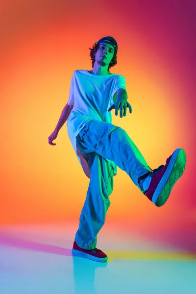 젊은 남성의 근접촬영 사진, 네온 라이트 댄스 홀에서 다채 로운 배경에 고립된 화려 한 옷을 입은 힙합 댄서. — 스톡 사진