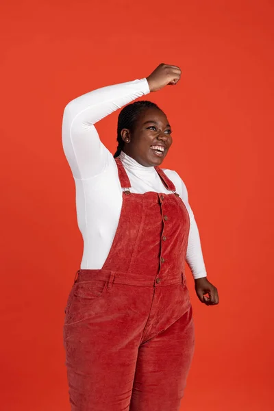 Helles Porträt einer glücklichen afrikanischen Frau isoliert auf rotem Studiohintergrund. Konzept menschlicher Emotionen, Gesichtsausdruck, natürliche Schönheit, Körperpositiv — Stockfoto