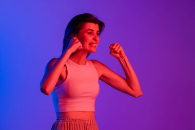 Mor, eflatun renkli stüdyo arka planında izole edilmiş beyaz bir kızın stüdyo fotoğrafı. İnsan duyguları kavramı, yüz ifadesi, kozmetik, gençlik