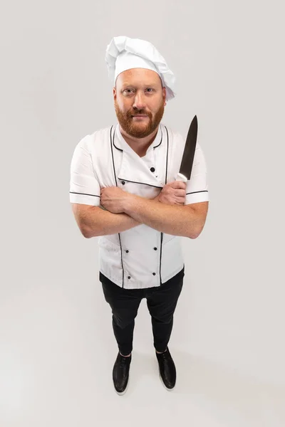 Hoge hoek uitzicht op hadsome baardman, kok, mannelijke chef-kok in wit uniform plezier geïsoleerd op witte achtergrond. Begrip werk, beroep, humor. — Stockfoto