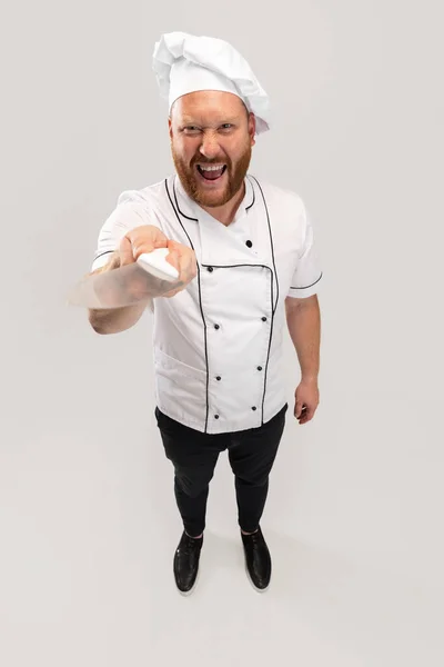 Hoge hoek uitzicht op hadsome baardman, kok, mannelijke chef-kok in wit uniform plezier geïsoleerd op witte achtergrond. Begrip werk, beroep, humor. — Stockfoto