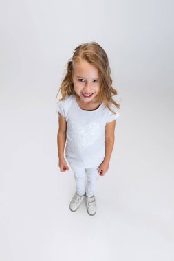 Beyaz stüdyo arka planında izole edilmiş şekilde poz veren uzun saçlı güzel bir kız. Mutlu çocukluk kavramı.