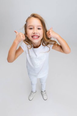 Beyaz stüdyo arka planında izole edilmiş şekilde poz veren uzun saçlı güzel bir kız. Mutlu çocukluk kavramı.