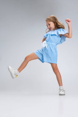 Beyaz stüdyo arka planında izole edilmiş günlük kıyafetlerle gülümseyen bir kızın tam boy portresi. Mutlu çocukluk kavramı. Neşeli çocuk. Mutlu görünüyor, mutlu.