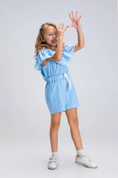 Full-length portrait of smiling girl in casual clothes having fun isolated on white studio background. Happy childhood concept. Sunny child. Looks happy, delighted — Stock Photo, Image