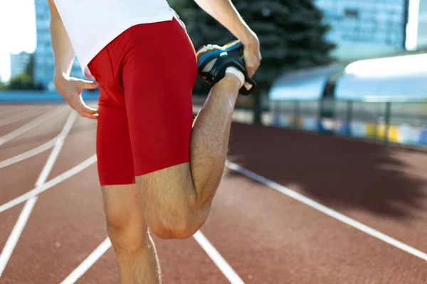 Cropped image of male athlete, runner training at public stadium, sport court or running track outdoors. Summer sport games. Mans legs — Stock Photo, Image