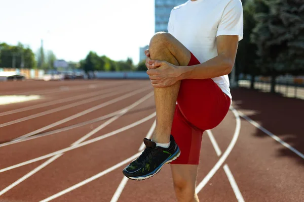 Imagem recortada de atleta masculino, treinamento de corredor em estádio público, quadra esportiva ou pista de corrida ao ar livre. Jogos desportivos de verão. Mans pernas — Fotografia de Stock