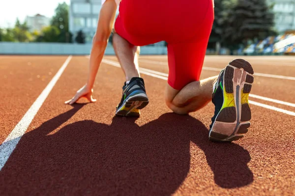 Image recadrée d'un athlète masculin, d'un coureur s'entraînant dans un stade public, un terrain de sport ou une piste de course à l'extérieur. Jeux de sport d'été. Mans jambes — Photo