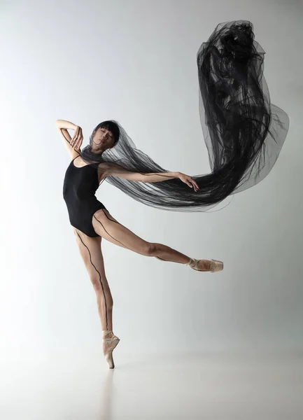 Retrato de una joven bailarina japonesa adorable bailando con tela transarente, telaraña negra aislada sobre fondo de estudio gris claro. Belleza, arte de línea, concepto de emociones. — Foto de Stock