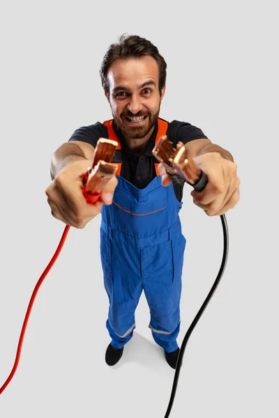 High angle view of young man, male auto mechanic or fitter in dungarees with work tools isolated over white studio background. — Stock Photo, Image