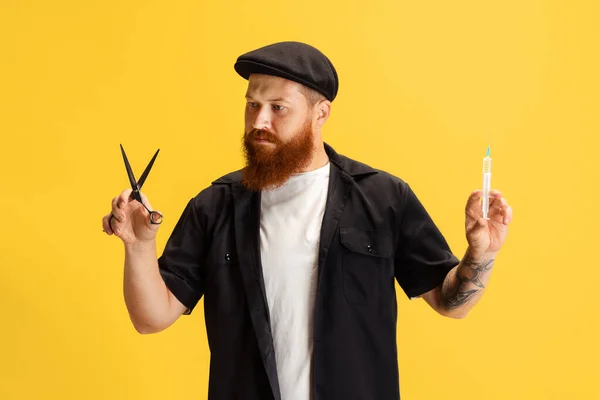 Ritratto comico di elegante uomo dalla barba rossa, barbiere in berretto nero che si diverte isolato su sfondo giallo. Concetto di emozioni, sentimenti. — Foto Stock