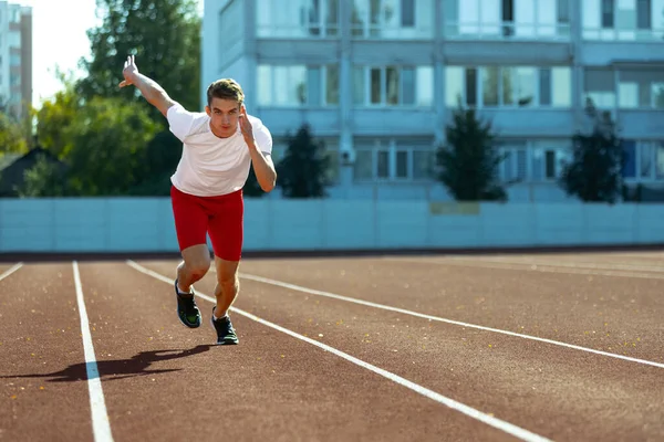 Young Caucasian man, male athlete, runner practicing alone at public stadium, sport court or running track outdoors. Summer sport games. — Stock Photo, Image