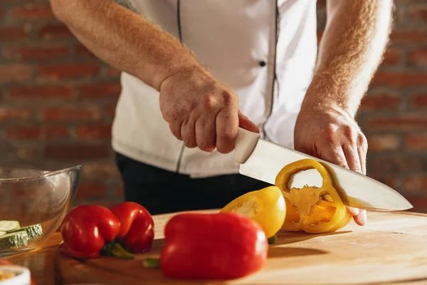 Primo piano mani di chef maschile, cuoco taglio insalata di verdure fresche nel suo caffè, cucina del ristorante. Concetto di una dieta corretta e sana. — Foto Stock