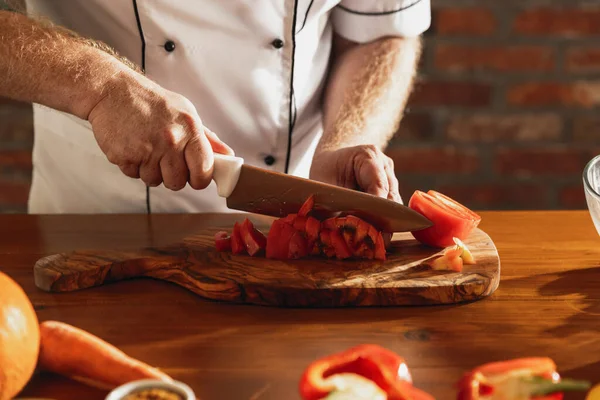 Primo piano mani di chef maschile, cuoco taglio insalata di verdure fresche nel suo caffè, cucina del ristorante. Concetto di una dieta corretta e sana. — Foto Stock