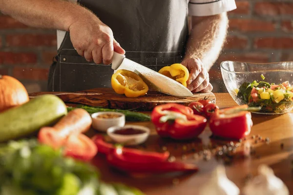 Primo piano mani di chef maschile, cuoco taglio insalata di verdure fresche nel suo caffè, cucina del ristorante. Concetto di una dieta corretta e sana. — Foto Stock