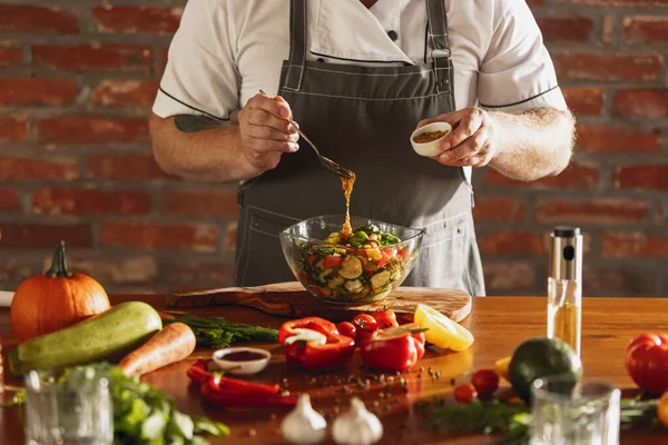 Primo piano mani di chef maschile, cuoco preparare insalata di verdure fresche nel suo caffè, cucina del ristorante. Concetto di una dieta corretta e sana. — Foto Stock